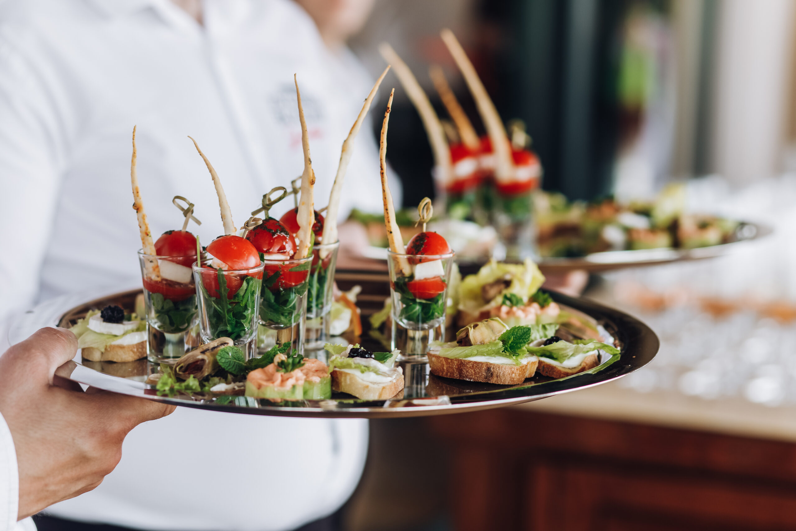 a waiter keeps a salver with snacks